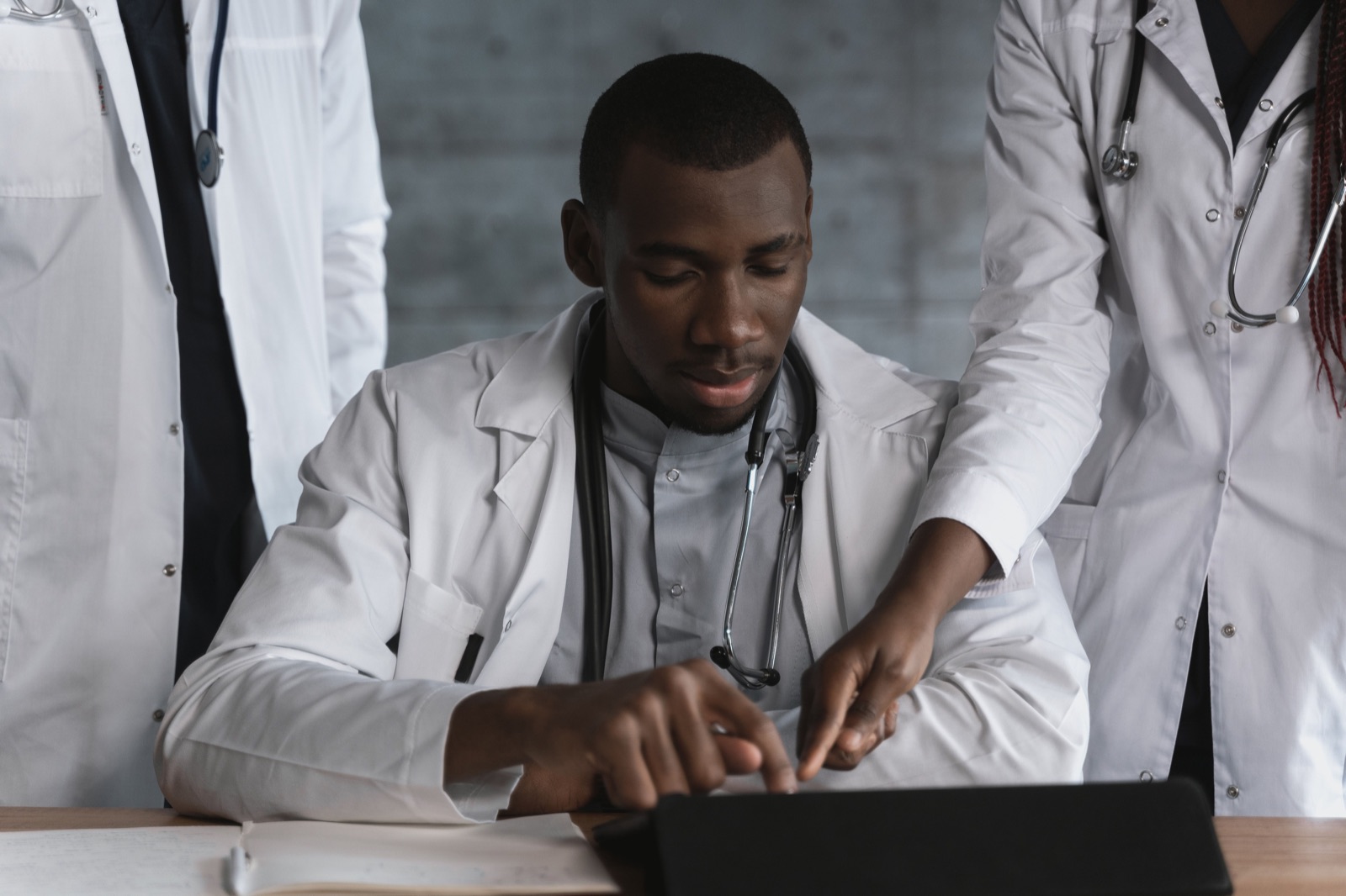 Illustrative stock photograph of healthcare colleagues reviewing information on a tablet